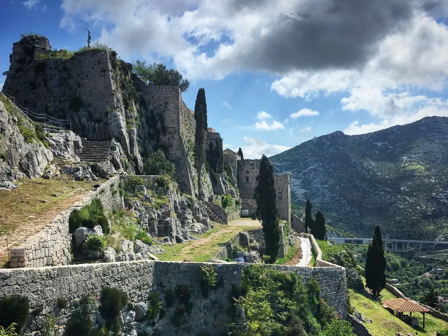 Festung Klis auf ihrem felsigen Bergrücken über Split unter bewölktem blauem Himmel