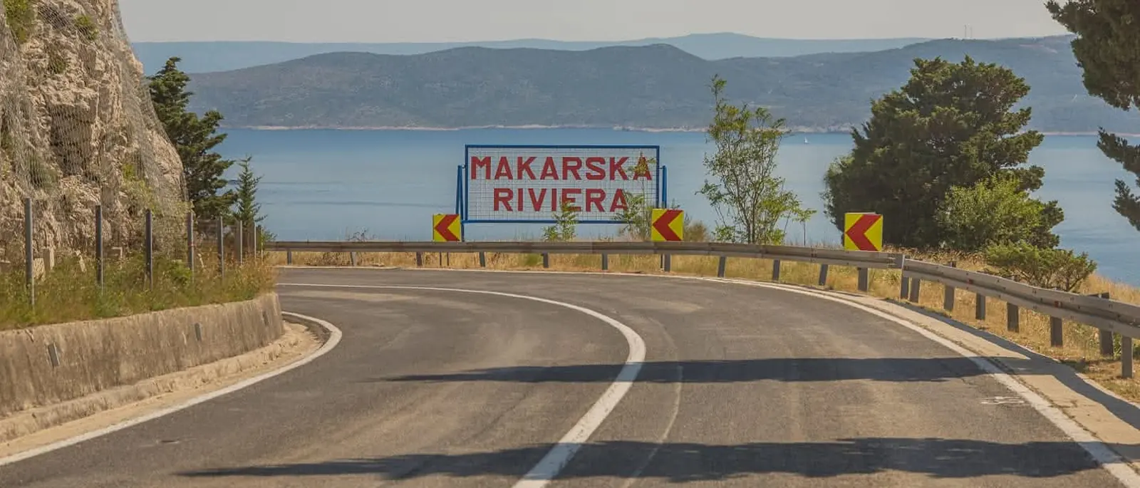 Die Küstenstraße nach Makarska mit dem Schild der Makarska Riviera